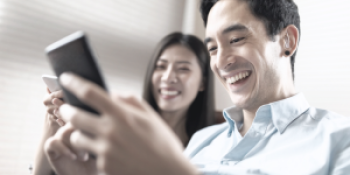 a smiling woman and man looking at a single phone